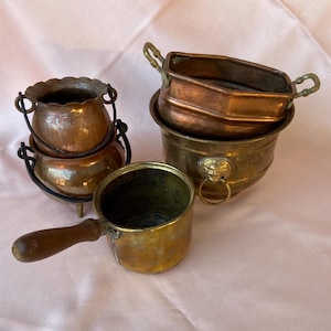 Könnte beinhalten: Vier antike Kupfer- und Messing-Töpfe mit Griffen. Die Töpfe sind ineinander verschachtelt, der größte unten und der kleinste oben. Die Töpfe sind alle in gutem Zustand und haben eine Patina.
