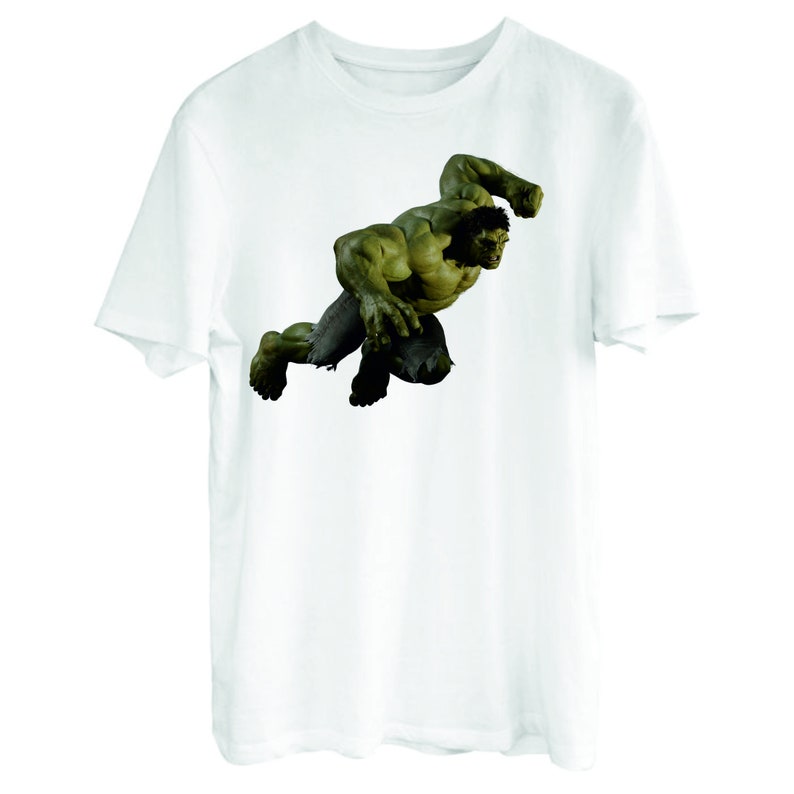 May include: White t-shirt with a green Hulk graphic. The Hulk is depicted in a dynamic pose, with his fists clenched and his face contorted in a fierce expression.