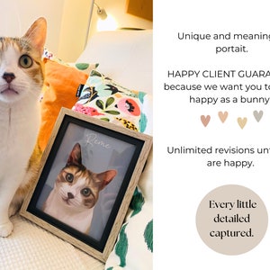 Op de afbeelding: Een ingelijst huisdierportret van een kat genaamd "Reme" met een lichtbruine houten lijst. De kat is een driekleurige kat met wit, oranje en zwart haar. Het portret ligt op een bed met een bloemig kussen erachter.
