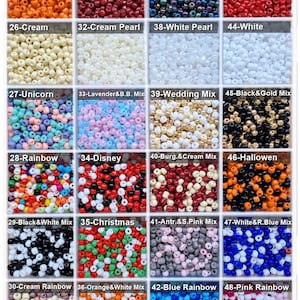 May include: A grid of twenty-four square compartments containing small, round, colorful beads. Each section is labeled with a number and a name, including colors like orange, burgundy, red, cream, white, black, and various multi-colored mixes.
