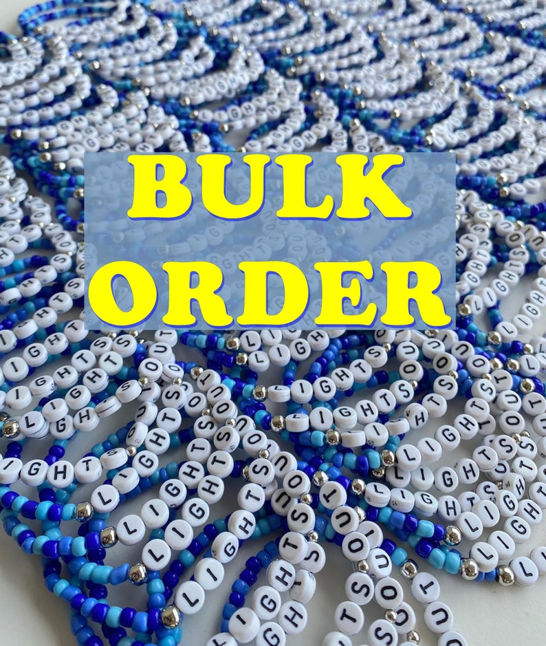 May include: A large collection of beaded bracelets featuring blue and white glass beads interspersed with silver-toned metallic spacers. Each bracelet includes white circular letter beads spelling out the phrase LIGHTS OUT in black text.