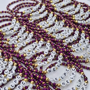 May include: A collection of beaded bracelets featuring alternating purple and metallic gold seed beads. Each bracelet includes white circular beads with the black printed letters N, E, L, P, and C, arranged to spell out the sequence NE LPC repeatedly.