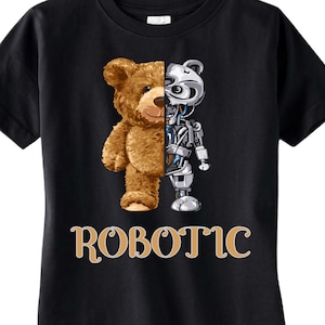 Puede incluir: Camiseta negra con un diseño dividido: una mitad es un oso de peluche marrón, la otra un robot plateado. La palabra "ROBOTIC" está impresa en dorado debajo. La camiseta es de material suave.