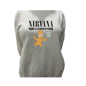 May include: A light gray sweatshirt featuring the text "NIRVANA NEVERMIND" in black. Below the text is a cartoon image of Bart Simpson reaching for a stack of money. The sweatshirt has long sleeves.