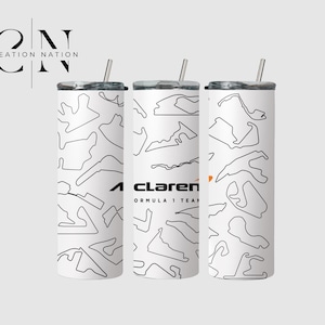 May include: Three white insulated tumblers with black outline race track designs. One tumbler features the McLaren Formula 1 Team logo in black and orange. Each tumbler has a silver straw and lid.