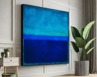 May include: Large abstract painting with a black frame. The artwork features a gradient of blues, from light turquoise at the top to deep navy at the bottom. The painting hangs on a white wall, with a plant in a striped pot nearby.