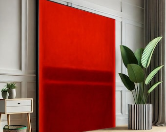 May include: Large abstract painting with a vibrant red color and a black frame. The artwork features a horizontal band of darker red near the center. The painting is displayed in a room with a side table, plants, and a striped planter.