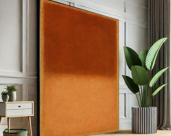 May include: Large, rectangular orange velvet wall art with a black frame. The artwork is a gradient of orange hues, creating a modern and minimalist aesthetic. The piece is displayed in a room with a plant in a striped pot and a small side table.
