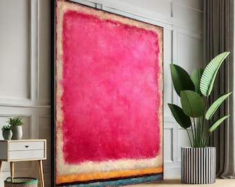 May include: Large abstract painting with a vibrant pink center, framed in black. The artwork features a textured surface with a white, gold, yellow, and blue horizontal band at the bottom. The painting is displayed in a well-lit room with a plant in a striped pot.