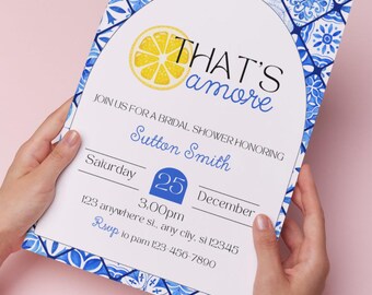 Puede incluir: Una invitación de despedida de soltera blanca con un borde estampado en azul y blanco. La invitación presenta una ilustración de limón y el texto "THAT'S amore". La invitación es para Sutton Smith el 25 de diciembre a las 3:00 pm. La dirección es 123 anywhere st., any city, si 12345. RSVP al 123-456-7890.
