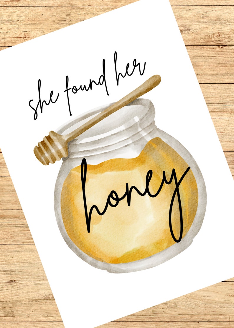 May include: A watercolour illustration of a glass jar filled with honey and a wooden honey dipper. The text "she found her honey" is written in black cursive above the jar.