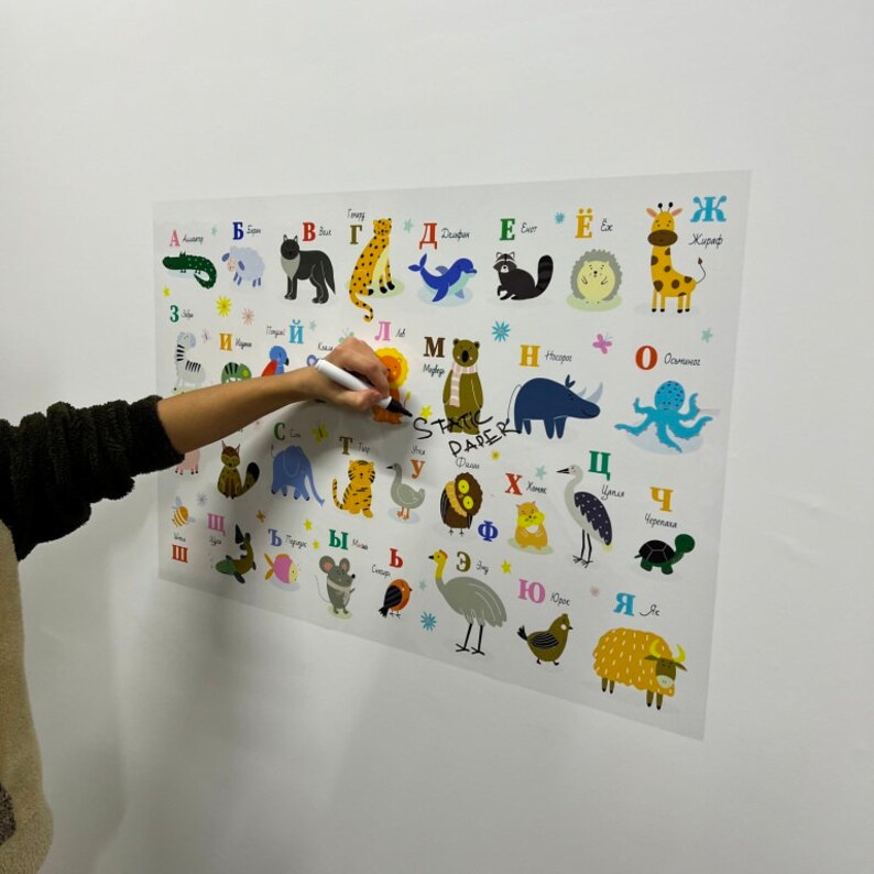 K&ouml;nnte beinhalten: Ein farbenfroher Alphabet-Chart mit Tieren und ihren Namen in Russisch. Der Chart ist auf wei&szlig;em Papier gedruckt und hat einen wei&szlig;en Hintergrund. Die Buchstaben sind in einer fetten, bunten Schriftart. Die Tiere sind im Cartoon-Stil illustriert.