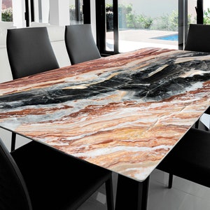May include: A rectangular dining table with a black metal base and a marble top with brown, black, and white swirling patterns.