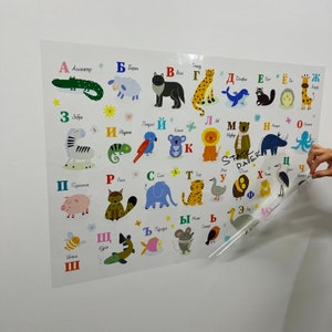 K&ouml;nnte beinhalten: Ein farbenfroher Alphabet-Chart mit Tieren und ihren Namen in Russisch. Der Chart ist auf einer transparenten Plastikfolie gedruckt und soll als Lernhilfe f&uuml;r Kinder verwendet werden.