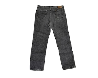 May include: A pair of acid wash gray denim jeans. The jeans have a classic five-pocket design, a button and zipper closure, and a brown leather Lee brand patch on the back waistband.