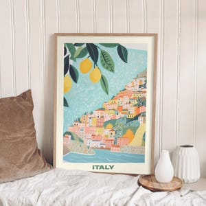 Puede incluir: Una ilustración colorida de un pueblo costero en Italia con un limonero en primer plano. El texto "ITALIA" está en la parte inferior de la imagen.