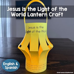 Może przedstawiać: Ręcznie wykonana żółta papierowa latarnia z uchwytem. Latarnia zawiera napis "Jezus jest Światłem Świata" oraz werset biblijny. Rękodzieło przeznaczone jest dla osób mówiących po angielsku i hiszpańsku.