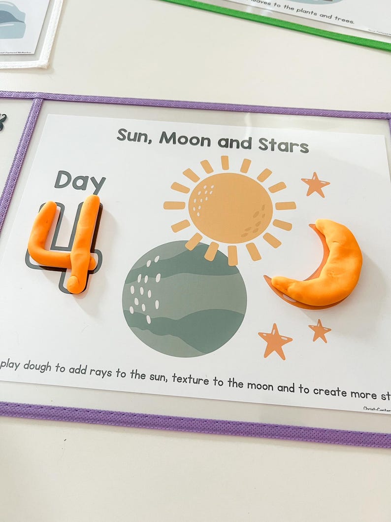 May include: A white card with the words "Day 4" in orange play dough. The card also has a picture of the sun, moon, and stars. The text "Sun, Moon and Stars" is at the top of the card. The text "play dough to add rays to the sun, texture to the moon and to create more stars" is at the bottom of the card.