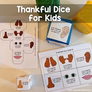 May include: A printable set of gratitude dice for kids. The dice are designed to help children focus on things they are thankful for. The dice feature images of body parts, such as feet, hands, ears, nose, eyes, and mouth. The printable sheet includes instructions for cutting and assembling the dice. The text on the dice reads "I am thankful that I can use my... to..."