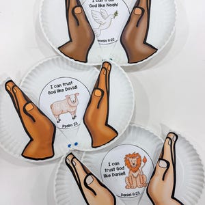 May include: Three white paper plate crafts featuring cutouts of praying hands. Each plate displays a circular graphic with a religious theme: a dove with the text I can trust God like Noah, a sheep with I can trust God like David, and a lion with I can trust God like Daniel.