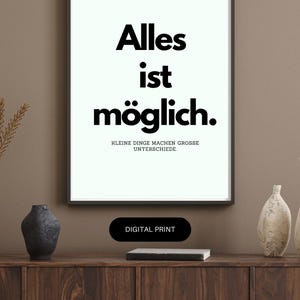 May include: A framed print with the words "Alles ist möglich" in bold black font, meaning "Everything is possible." Below, smaller text reads "Kleine Dinge machen grosse Unterschiede." A digital print.