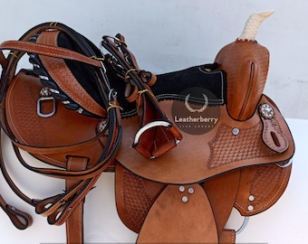 May include: A brown leather saddle with a black suede seat and a white horn. The saddle is decorated with stitching and a woven pattern. The saddle is accompanied by a brown leather bridle with a black strap.