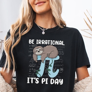 May include: Black t-shirt featuring the text "BE IRRATIONAL IT'S PI DAY" and a sloth graphic resting on a light blue Pi symbol with green vines. The shirt is a comfort colors style.