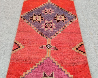 Puede incluir: Una alfombra de pasillo roja, rosa y morada con un patrón geométrico. La alfombra tiene un diseño tradicional marroquí con detalles intrincados.