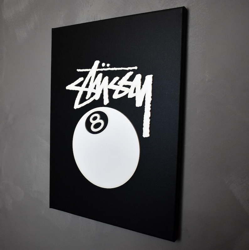 May include: A black canvas print with a white 8-ball and the word "STUSSY" in white lettering.