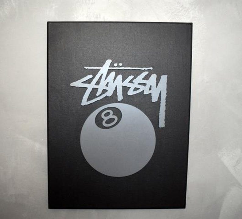 May include: Black box with a silver 8-ball and the word "STUSSY" in silver lettering.