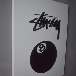 May include: A black and white canvas print featuring the Stussy logo and a black 8-ball.