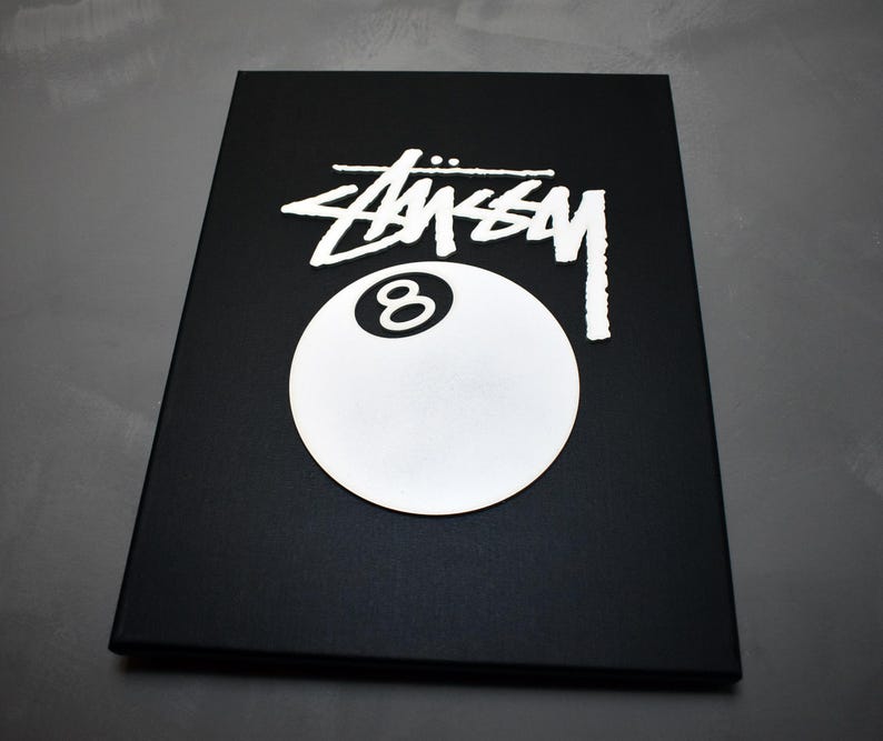 May include: Black and white graphic of a 8-ball with the word "STUSSY" in white lettering on a black background.