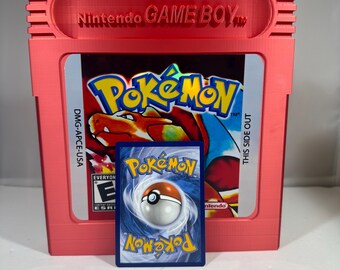 May include: A red Game Boy cartridge case with the text "Nintendo GAME BOY" on the top. The case is closed and shows the front of a Pokemon game cartridge with the text "Pokemon" and "DMG-APCE-USA". A Pokemon trading card is in front of the case.
