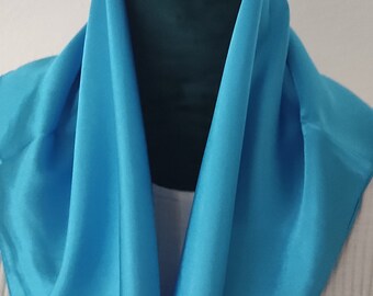 Tissu carré turquoise "silkfeeling". Léger et confortable à porter. Une touche de couleur pour votre garde-robe, adaptée à toutes les occasions.