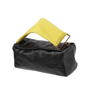 May include: A black leather handbag with a yellow leather strap and a gold metal clasp.