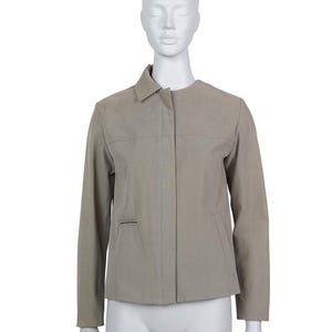 Pode incluir: Casaco bege com gola e mangas compridas. O casaco tem fecho de botão e dois bolsos frontais. A peça de roupa é exibida num manequim.