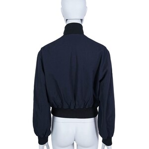 May include: Navy blue bomber jacket with a black collar, cuffs, and waistband, displayed on a mannequin. The back view showcases the jacket's design and fit. A casual outerwear piece, suitable for various occasions.
