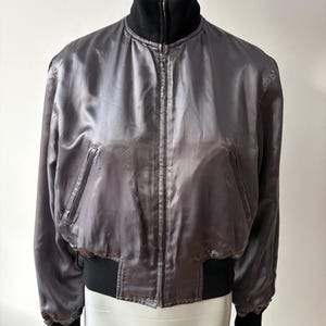 May include: A set of three ceramic mugs with a speckled, matte finish in cream, light grey, and dark grey. Each mug has a simple, minimalist design, suitable for coffee or tea.