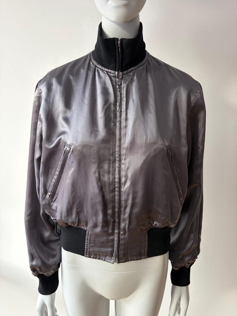 May include: A set of three ceramic mugs with a speckled, matte finish in cream, light grey, and dark grey. Each mug has a simple, minimalist design, suitable for coffee or tea.