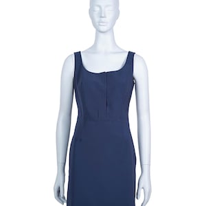 May include: A navy blue sleeveless dress with a square neckline and a fitted silhouette. The dress features a subtle seam detail down the front and a concealed zipper. The dress is displayed on a mannequin against a white background.