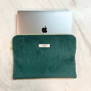 Housse ordinateur Velours Côtelé couleur Vert Sapin. Accessoire iPad et tablette.
On voit un macbook Pro Apple qui sort à moitié de la housse AMMA