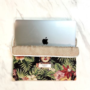 Housse ordinateur Frida Khalo en tissu Jacquard. Un PC portable MacBook Pro Apple se trouve dans la pochette.