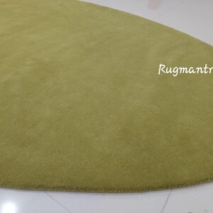 May include: A large, oval-shaped, green rug with a soft, plush texture. The rug is made of high-quality materials and is perfect for adding a touch of elegance to any room.