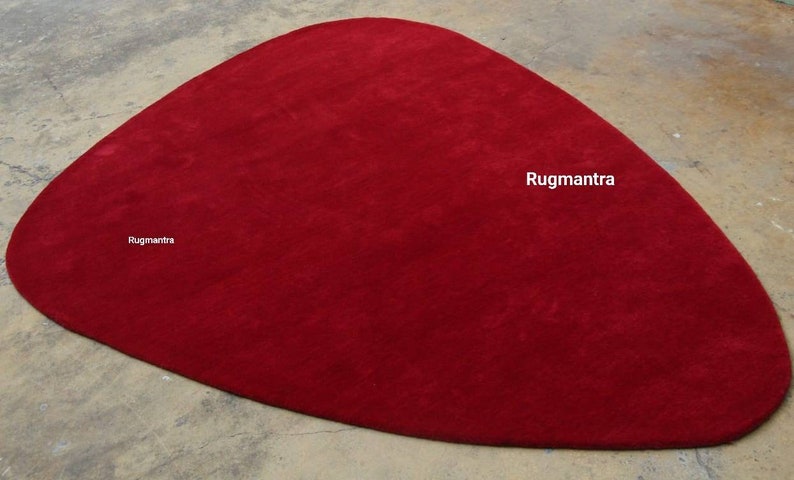 May include: A large, red, oval-shaped rug. The rug is made of a soft, plush material. The rug is perfect for adding a touch of color and style to any room.