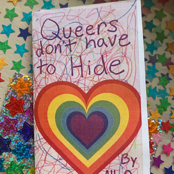 May include: A small, rectangular card with the text "Queers don't have to Hide" in purple handwritten font. A rainbow heart design is centered below the text. The card is signed "By Ally Q". The background is covered in colorful star stickers.