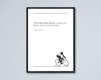 May include: Black framed print with the quote "Life is like riding a bicycle. To keep your balance, you must keep moving." by Albert Einstein. A black and white illustration of a cyclist is at the bottom.