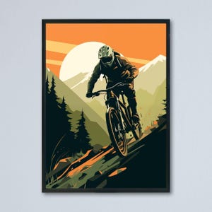 Puede incluir: Una impresión artística enmarcada representa a un ciclista de montaña descendiendo por una pendiente pronunciada. La obra de arte presenta una vibrante puesta de sol naranja, terreno verde y marrón y árboles silueteados. El ciclista lleva casco y monta una bicicleta de montaña negra.