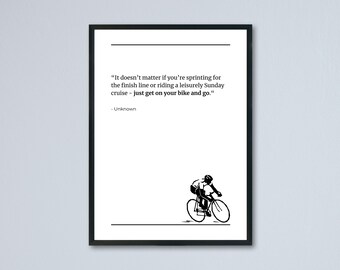May include: Black framed print with a white background. The print features a cyclist illustration and the quote: "It doesn't matter if you're sprinting for the finish line or riding a leisurely Sunday cruise - just get on your bike and go."