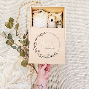 May include: A wooden keepsake box with a floral design and the name "Noah" engraved on it. The box also includes the date "September 8th, 2023", weight "6 lbs 2 oz", and time "5:05 AM".