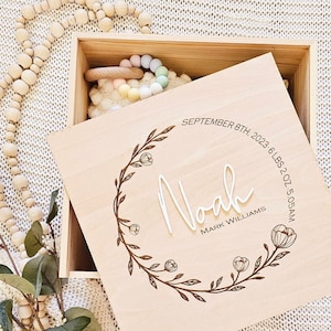 May include: A wooden keepsake box with a floral design engraved on the lid. The lid reads "Noah, Mark Williams, September 8th, 2023, 6 lbs 2 oz, 5:05 AM".